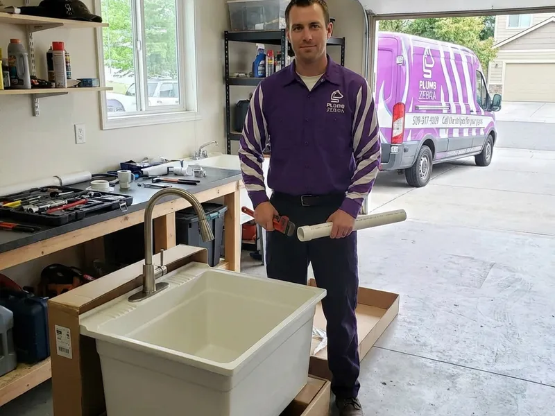 Professional plumber working on utility sink installation service in Spokane - PlumbZebra quality workmanship